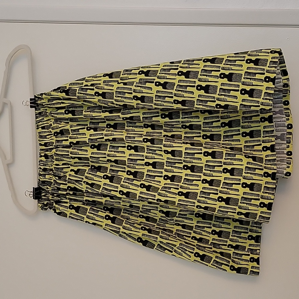 Neon yellow skirt. Hair brushes. Stylist.